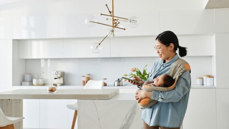 赤ちゃんを抱きながらスマホで情報収集する女性