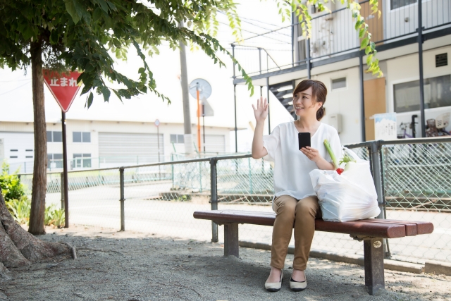 知り合いとばったり会い手を振る女性